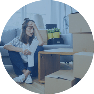 stressed woman sitting on floor with moving boxes